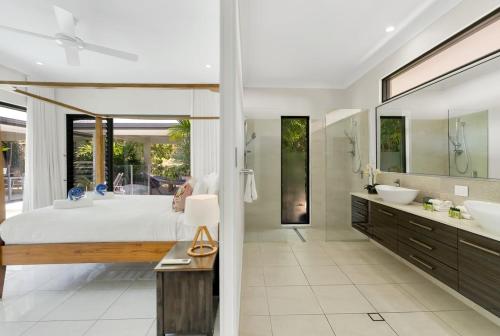 a bathroom with a large bed and two sinks at Belle Escapes Castaways in Palm Cove