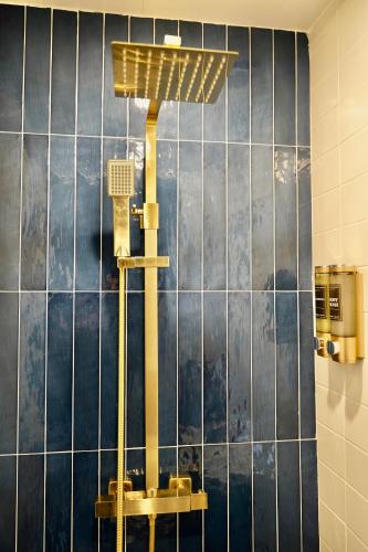 a shower in a bathroom with blue tiles at THE COZY CAVE includes Private entry PS5 Netflix in Castleton