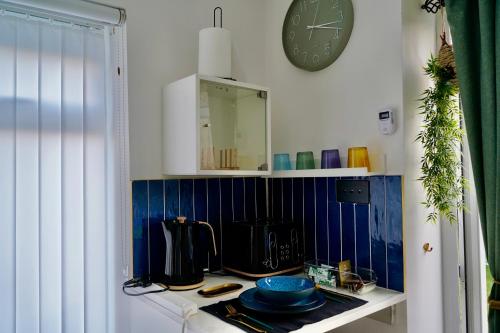 a kitchen with a counter and a clock on the wall at The Cozy Cave in Castleton