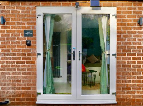 a white french door on a brick wall at The Cozy Cave in Castleton
