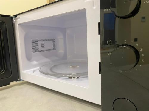 eine Mikrowelle mit einem CD-Player darin in der Unterkunft Apartment Modern & Cozy - City Center Saldus in Saldus