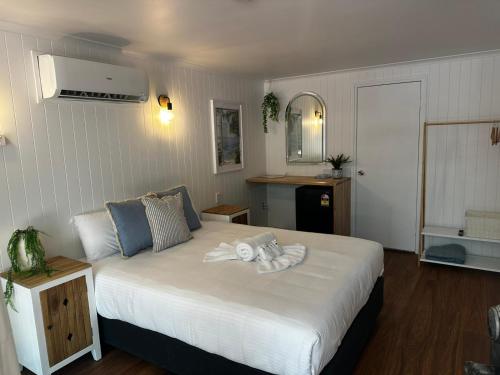 een slaapkamer met een bed met een handdoek erop bij Central Motel Mooloolaba in Mooloolaba
