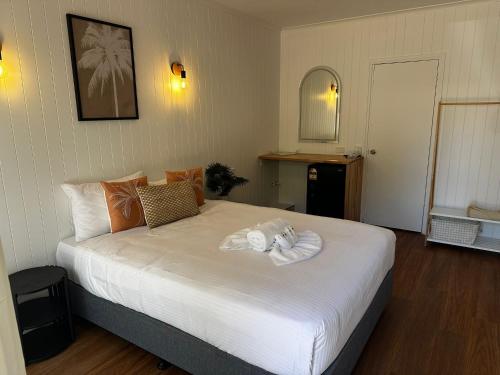 een slaapkamer met een groot bed met een handdoek erop bij Central Motel Mooloolaba in Mooloolaba