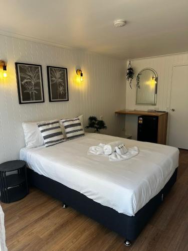 a bedroom with a large bed with towels on it at Central Motel Mooloolaba in Mooloolaba