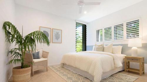 a bedroom with a bed and a potted plant at Luxury On The Bay - Wanda in Suffolk Park