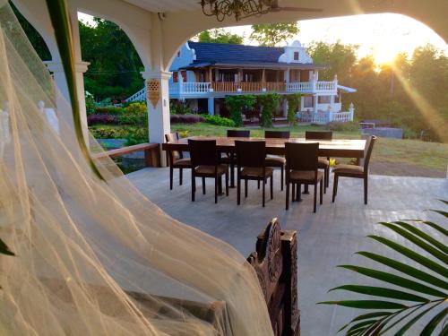 a table and chairs on a patio with a house at Ataalaya Farmhouse in Batangas City
