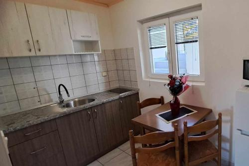 una cucina con tavolo, lavandino, tavolo e sedie di Apartment Podaca 11274a a Viškovića Vala
