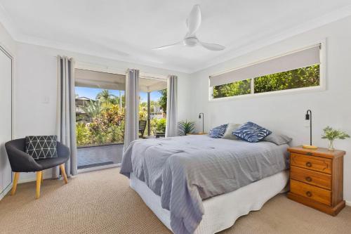 a bedroom with a bed and a window and a chair at Rainbow Tides - Rainbow Beach in Rainbow Beach