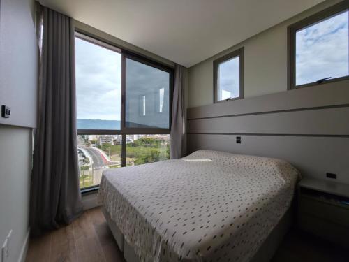 En eller flere senge i et værelse på Apartamento com Vista Mar e Piscina