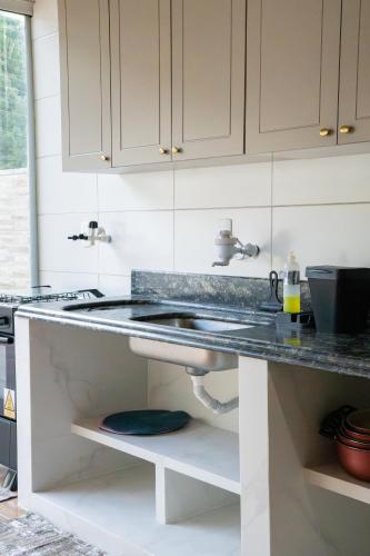 een keuken met witte kasten en een spoelbak bij Casa Alemã Alfredo Wagner SC in Alfredo Wagner