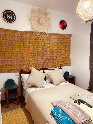 ein Schlafzimmer mit einem Bett und einem Fenster mit einem Vorhang in der Unterkunft Momo Surf Housse in Wassane