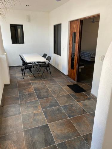 een kamer met een tafel en stoelen op een betegelde vloer bij Costa Ayala - Bungalow 6 with 2dbl beds, 2 sofas in Los Ayala
