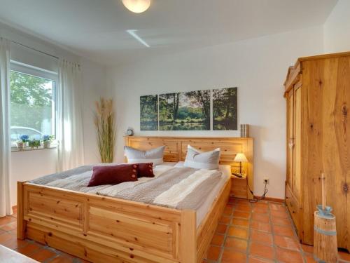 ein Schlafzimmer mit einem großen Holzbett in einem Zimmer in der Unterkunft Spreewald holiday home - Esox in Steinkirchen