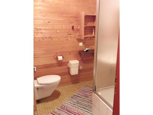 een badkamer met een toilet en houten wanden bij Main building Neumühle in Lutzerath