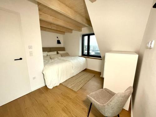 ein Schlafzimmer mit einem Bett, einem Fenster und einem Stuhl in der Unterkunft Luxury holiday home DS11 in Staberdorf