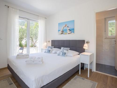 a bedroom with a large white bed and a window at Villa in Bol with swimming pool in Bol