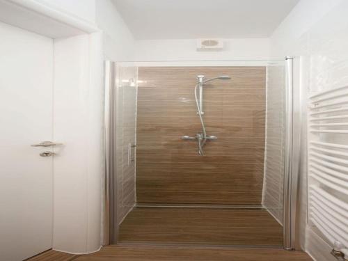 a shower stall in a bathroom with a wooden floor at Villa in Korni with swimming pool in Kornić