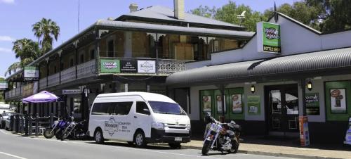 a white van parked in front of a building with motorcycles at Mannum Hotel in Mannum