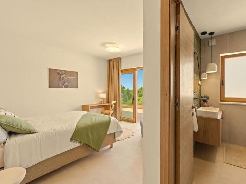 een slaapkamer met een bed en een badkamer bij Villa Casa Del Oro in Vrsar