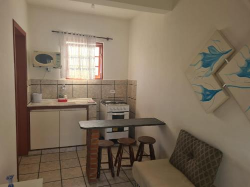 uma cozinha com uma mesa e bancos em uma sala em Pousada Bertioga em Bertioga