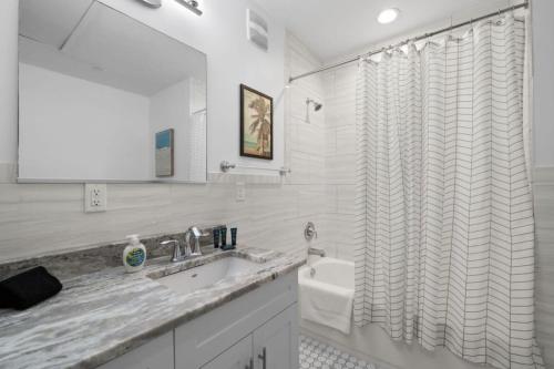a bathroom with a sink and a shower curtain at Casa Ybor Apartments on 7th Ave in Tampa
