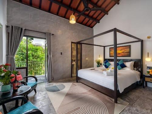 a bedroom with a large bed and a living room at Emerald Coast House in An Bàn (2)