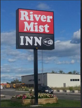 a sign for a river mustim in front of a building at River Mist INN in Sturgeon Falls
