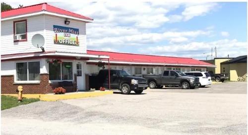 a building with a truck parked in front of it at River Mist INN in Sturgeon Falls