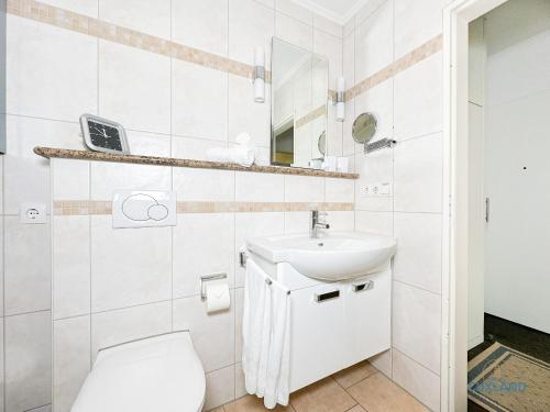 un bagno bianco con un water e un lavandino di Ferienwohnung 19 Heinrich-Grube Weg a Döse