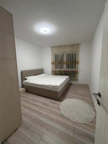 een slaapkamer met een bed en een houten vloer bij Genial Apartments in Gjakove