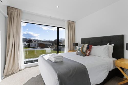 ein Schlafzimmer mit einem großen Bett und einem großen Fenster in der Unterkunft Flexible Bed Options, Private Back Yard, Car Park in Albert Town