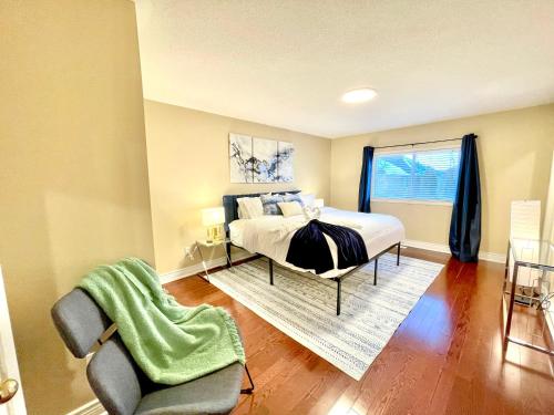 ein Schlafzimmer mit einem Bett, einem Stuhl und einem Fenster in der Unterkunft Maison Laurier, Modern 5B4B Home Inc BSMT Free parking, Close to trails in Richmond Hill