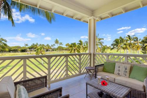 a porch with a couch and chairs and palm trees at Spacious 2BR condo with lanai & pool in Waikoloa