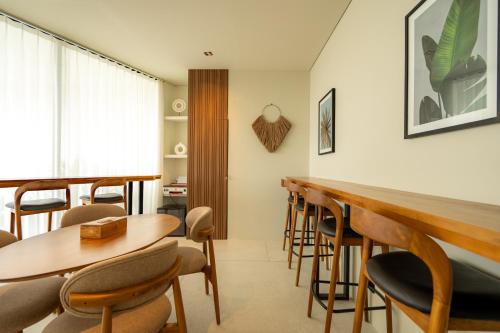 een eetkamer met houten tafels en stoelen bij Sore Escape Tumbak Bayuh by Betterplace in Tumbak Bayuh