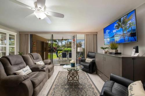 a living room with a couch and a ceiling fan at Tropical condo with pools lanai & BBQ in Waikoloa Village