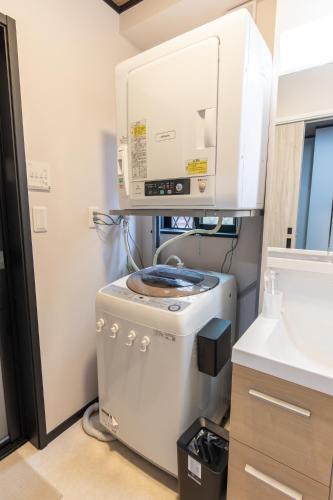 a washer and dryer in a kitchen next to a sink at 貸切新築ヴィラ l 最大9名 l 小田原城徒歩14分 l 無料P l 箱根板橋駅徒歩9分 l SENU VILLA Minamicho - Odawara in Odawara