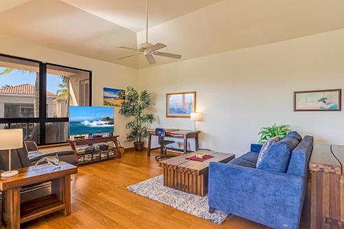 a living room with a blue couch and a table at Tropical 1BR condo with pool & private lanai in Waikoloa
