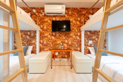 a room with two beds and a tv at GRAND CAVE MOTOMACHI in Yokohama