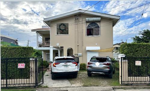 two cars parked in front of a house at City Garden Apartment in Belize City
