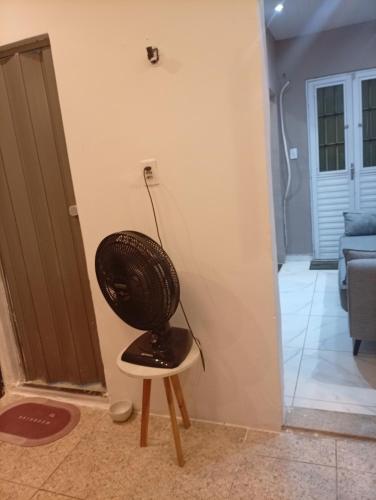 a black chair sitting in the corner of a room at Flat aconchegante na maraponga in Fortaleza