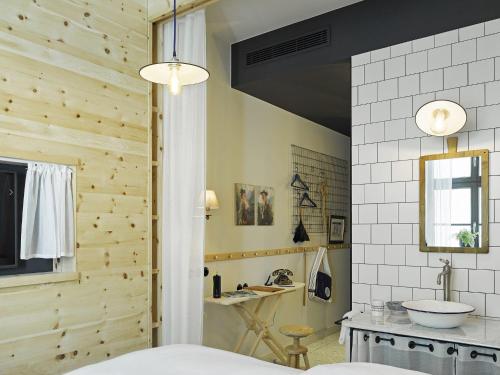 ein Badezimmer mit einer Holzwand und einem Waschbecken in der Unterkunft 25hours Hotel The Royal Bavarian in München