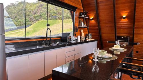 a kitchen with a counter and a large window at Chalé A-Frame - Chalé de Cima in Ouro Preto