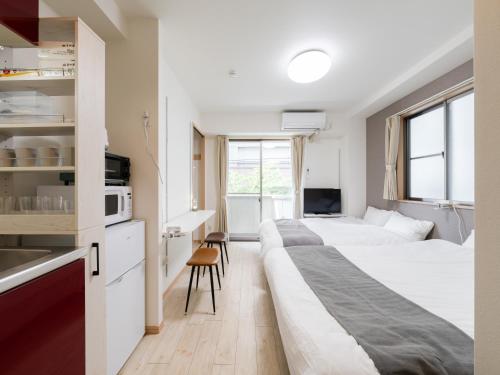 a hotel room with two beds and a kitchen at Ikebukuro 10min walk, Shinjuku 10min, Switch, Free Wi-Fi ,PocketWi-Fi in Tokyo