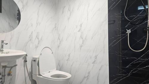 un bagno bianco con un water e un lavandino di TharaD place a Samut Sakhon
