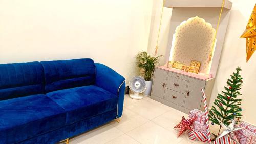 een blauwe bank in een woonkamer met een kerstboom bij The Brij Retreat , 50 mtr from Shri Krishna Janambhumi in Mathura