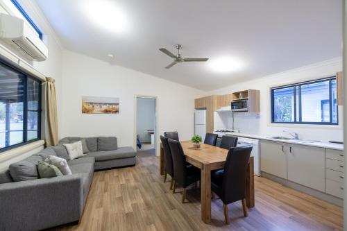 a kitchen and living room with a table and a couch at Yarra Holiday Park in Stuarts Point