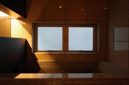 ein Bad mit Fenster in einem Zimmer in der Unterkunft 小樽旅亭 蔵群 in Otaru