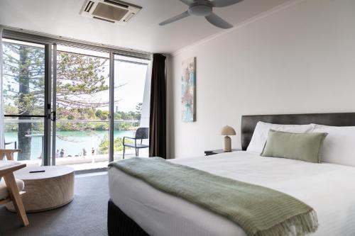 a bedroom with a large bed and a large window at Brunswick River Inn in Brunswick Heads