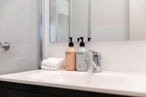 two bottles of wine are sitting on a bathroom sink at Brunswick River Inn in Brunswick Heads