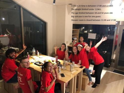 a group of people in red shirts sitting at a table at MAKOTO GUESTHOUSE -Limited Weight under 120kg, Age under 50years old- in Tokyo